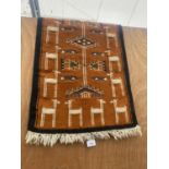 A SMALL HANDMADE PERUVIAN RUG WITH LLAMA PATTERN