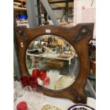 A VINTAGE OAK FRAMED ARTS AND CRAFTS BEVELLED GLASS MIRROR 65CM X 65CM