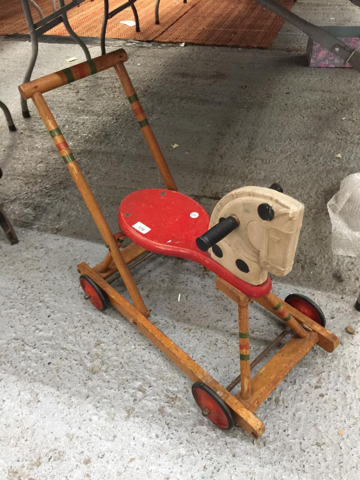 A VINTAGE WOODEN HORSE WITH WHEELS AND A HANDLE