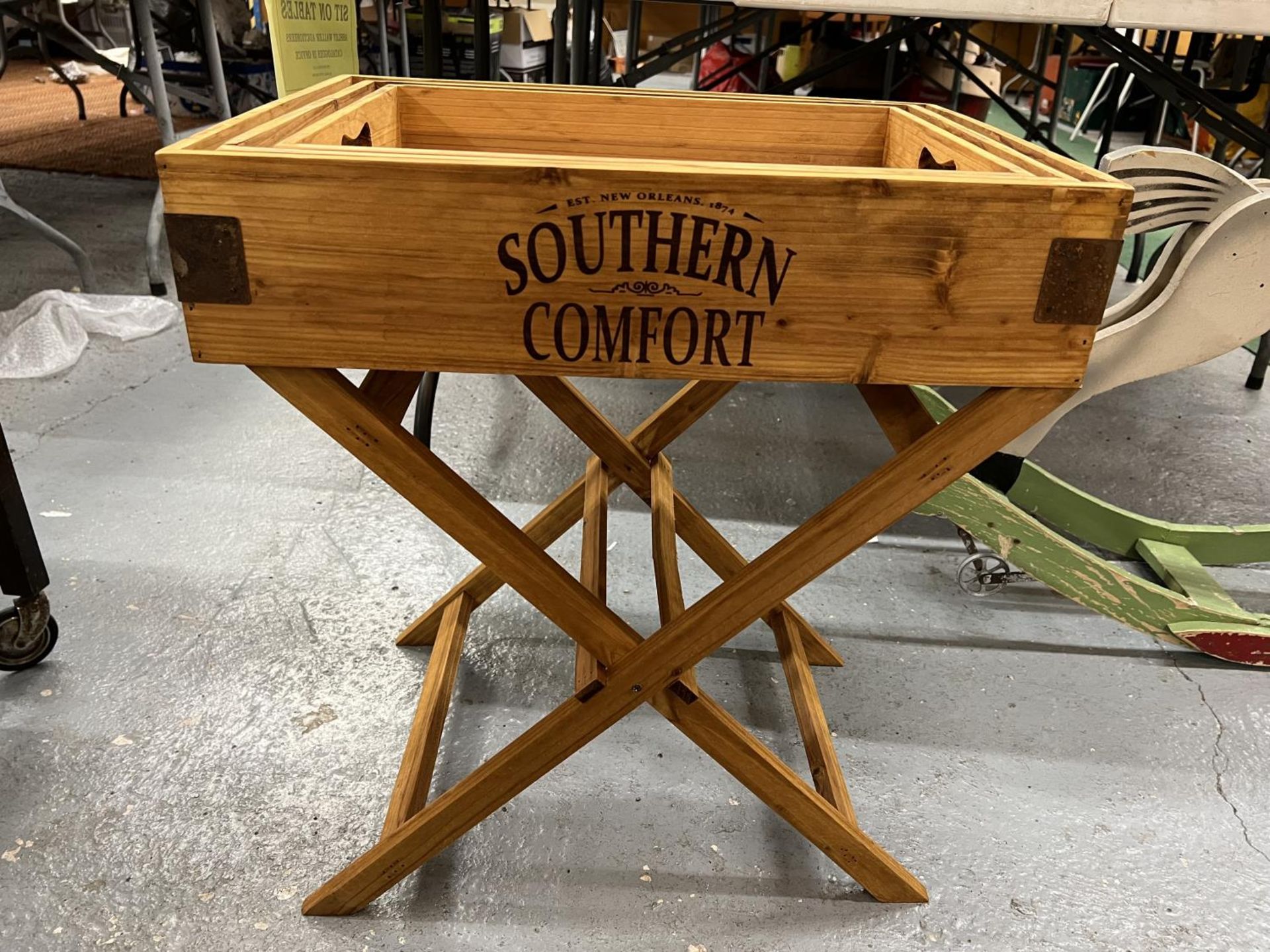 A PINE STAND SUPPORTING THREE 'SOUTHERN COMFORT' TRAYS OF GRADUATING SIZES