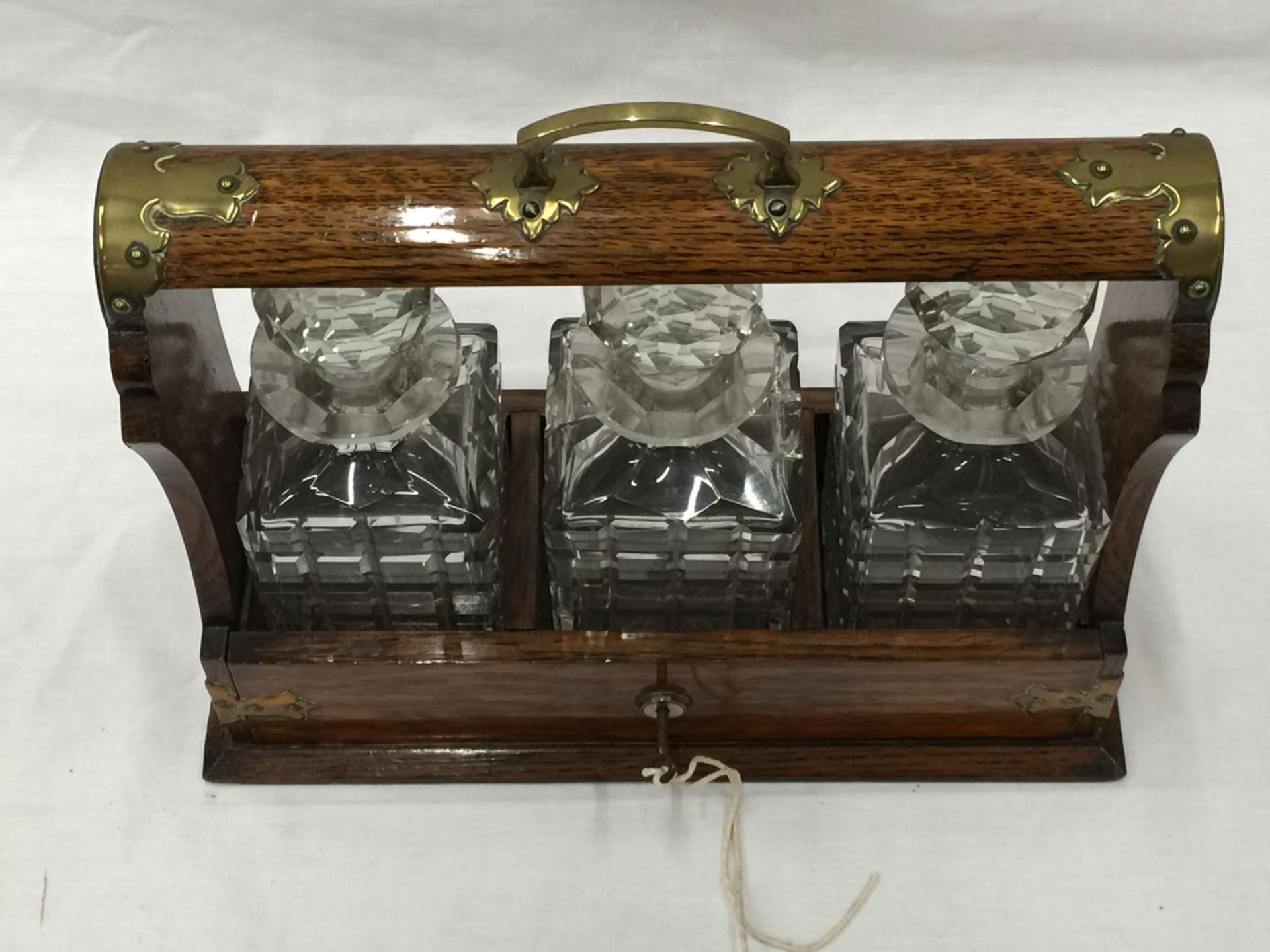 A VINTAGE MAHOGANY TANTALUS DECANTER SET WITH BRASS DETAILING AND A KEY - Image 4 of 9