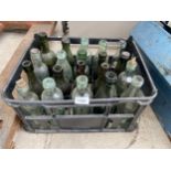 A CRATE CONTAINING VARIOUS CLEAR AND GREEN GLASS BOTTLES SOME BEARING NAMES