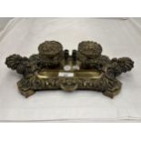 AN ORNATELY DECORATED BRASS DESK TIDY INCLUDING INKWELL WITH POT LINER