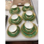 FIVE AYNSLEY GREEN AND GILT TRIOS PLUS A CUPA AND SAUCER