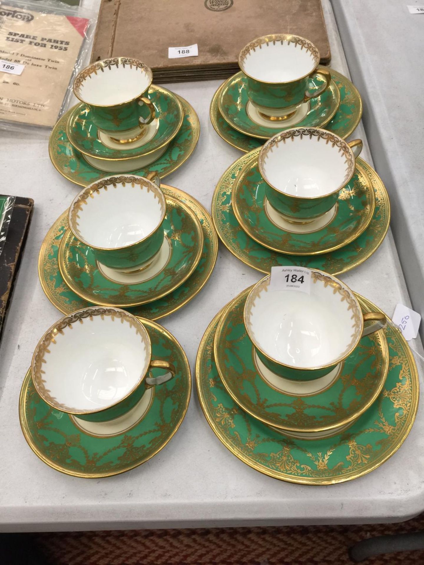FIVE AYNSLEY GREEN AND GILT TRIOS PLUS A CUPA AND SAUCER