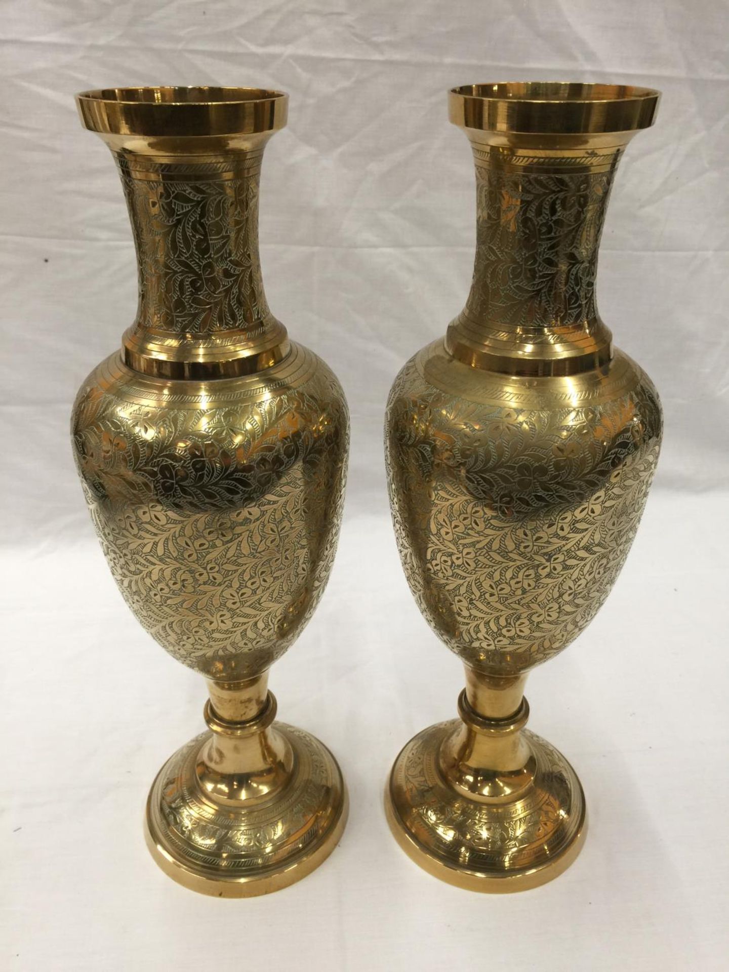 A PAIR OF HEAVY BRASS INDIAN STYLE VASES WITH ETCHED FLORAL LEAF DESIGN H: 45CM