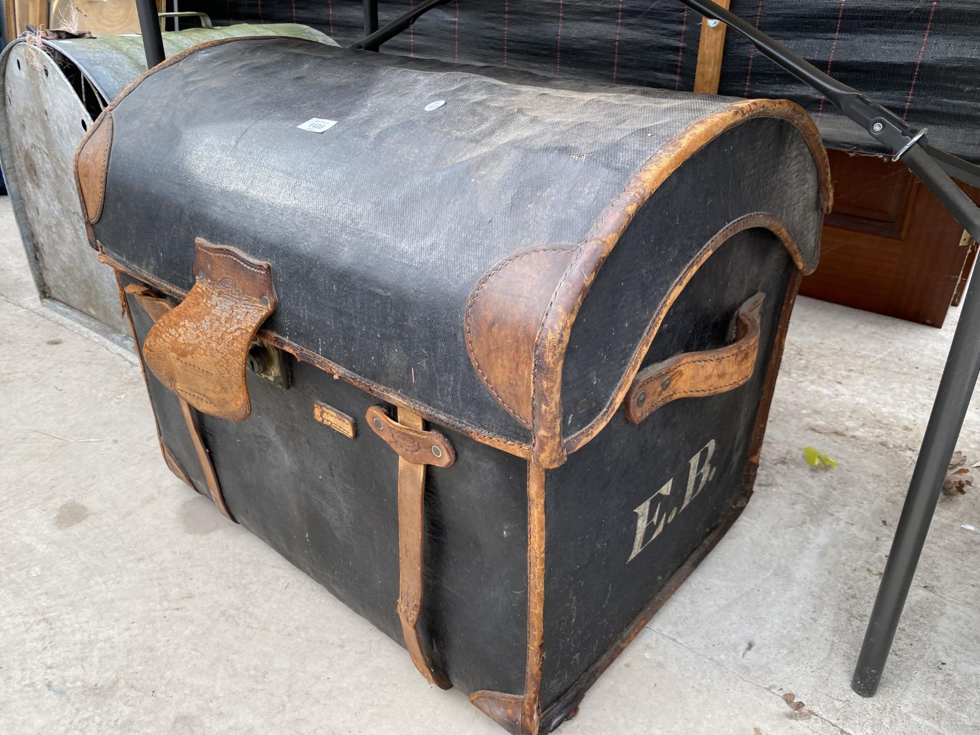 A VINTAGE LEATHER COVERED DOMED TOPPED TRAVEL TRUNK