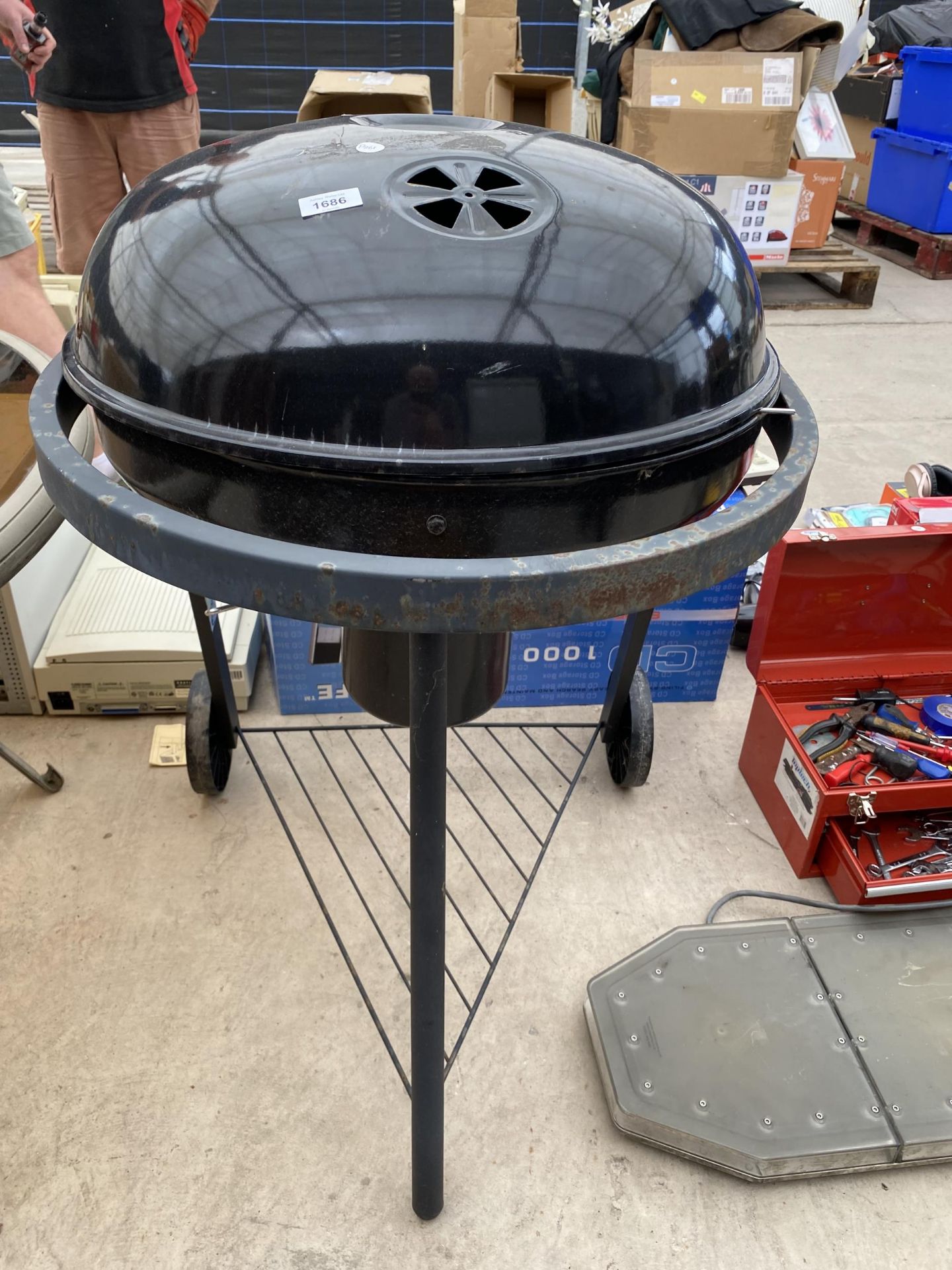 A CHARCOAL BBQ WITH TWO WHEELED BASE
