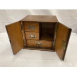 AN OAK SMOKERS CABINET WITH THREE ENCLOSED DRAWERS H: 30CM, W: 32CM