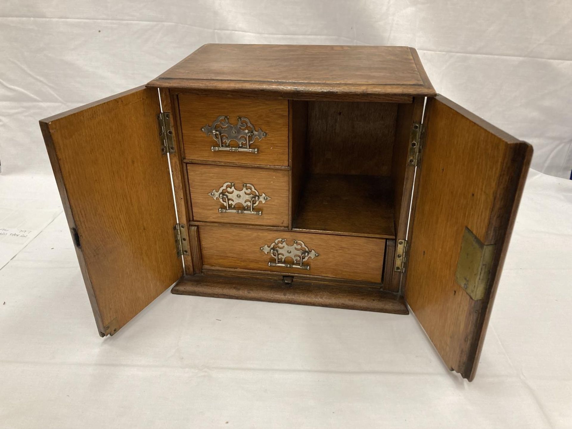 AN OAK SMOKERS CABINET WITH THREE ENCLOSED DRAWERS H: 30CM, W: 32CM