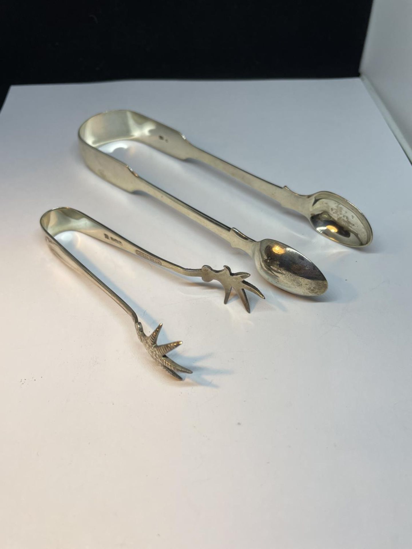 TWO PAIRS OF HALLMARKED SILVER TONGS TO INCLUDE A LONDON AND A SHEFFIELD