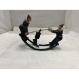 A CAST MODEL OF CLOWNS ON A SEE-SAW