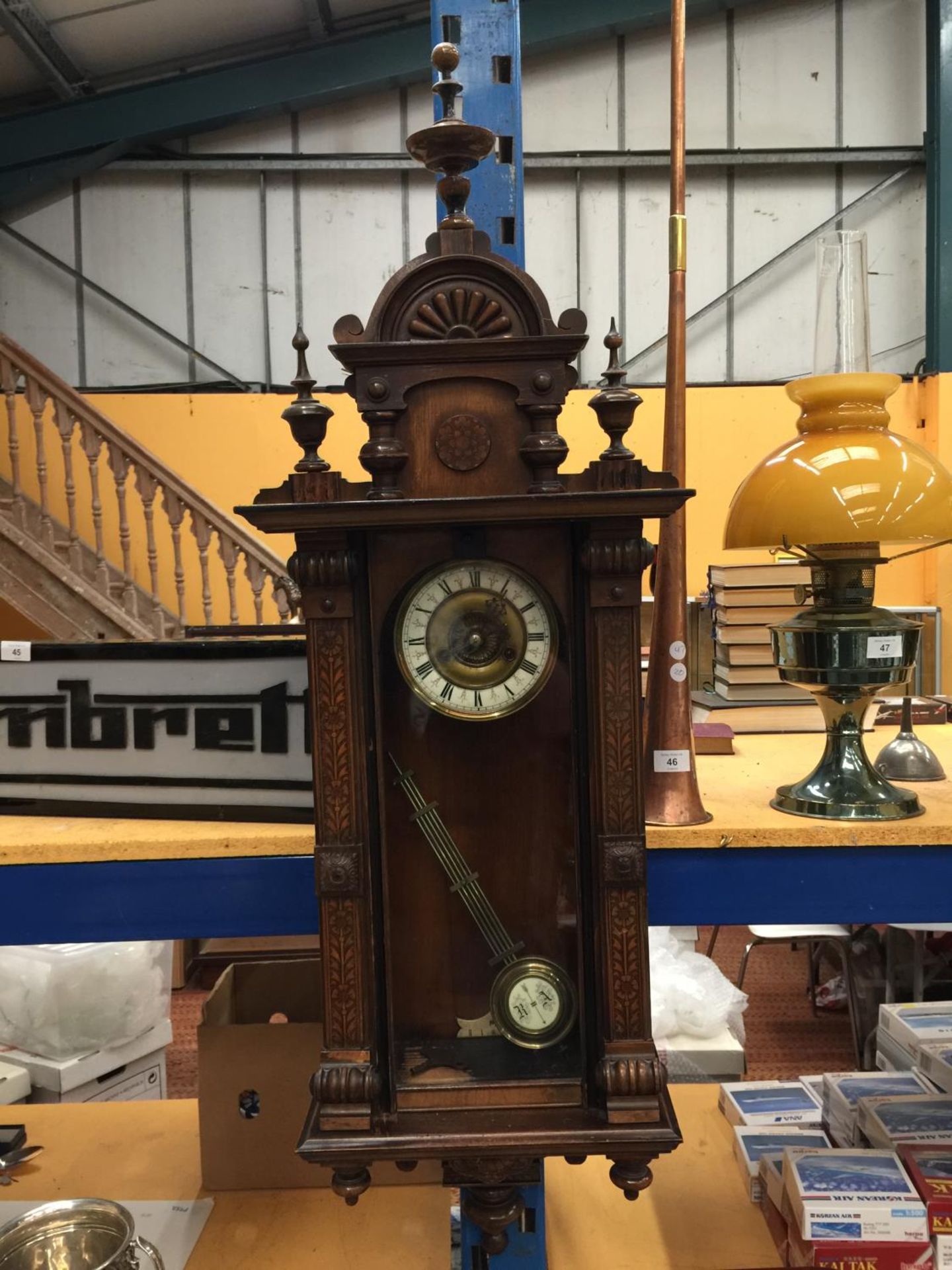 A LATE 19TH CENTURY VIENNA WALL CLOCK WITH ROMAN NUMERALS ON BRASS FACE AND PENDULUM WITH KEY H: