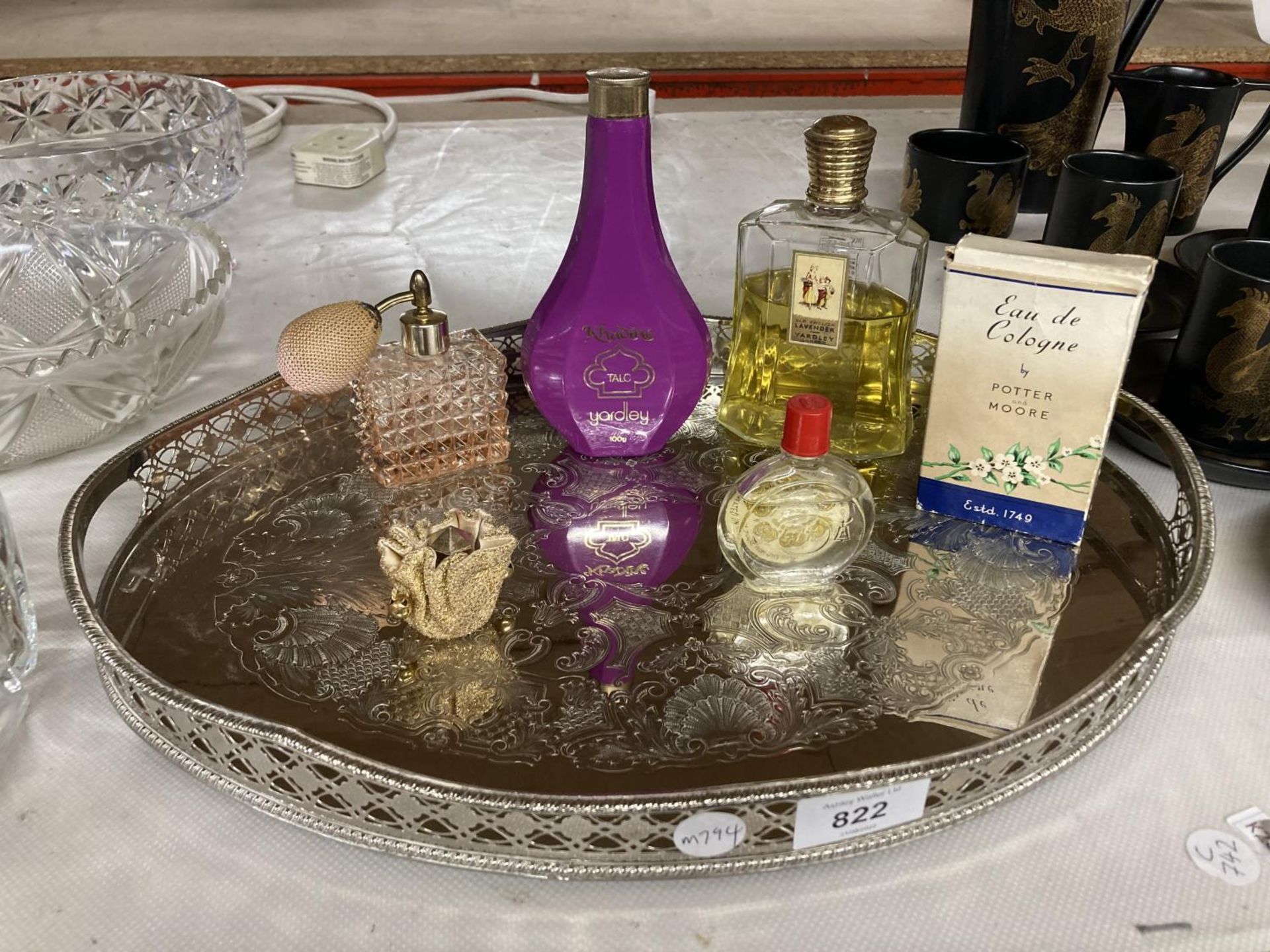 A SILVER PLATED GALLERIED TRAY CONTAINING VINTAGE PERFUMES, TALC AND A SCENT BOTTLE