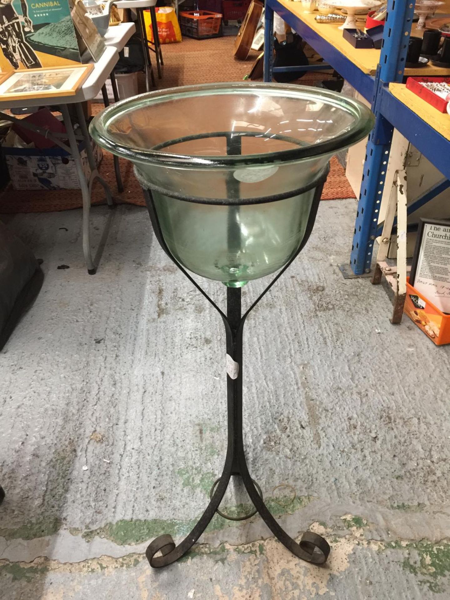 A LARGE BELL SHAPED GLASS BOWL ON A WROUGHT IRON STAND H: 96CM
