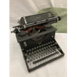 A VINTAGE IMPERIAL TYPEWRITER WITH DUST COVER