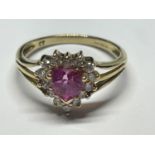 A 9 CARAT GOLD RING WITH A HEART SHAPED PINK STONE SURROUNDED BY CUBIC ZIRCONIAS SIZE I/J