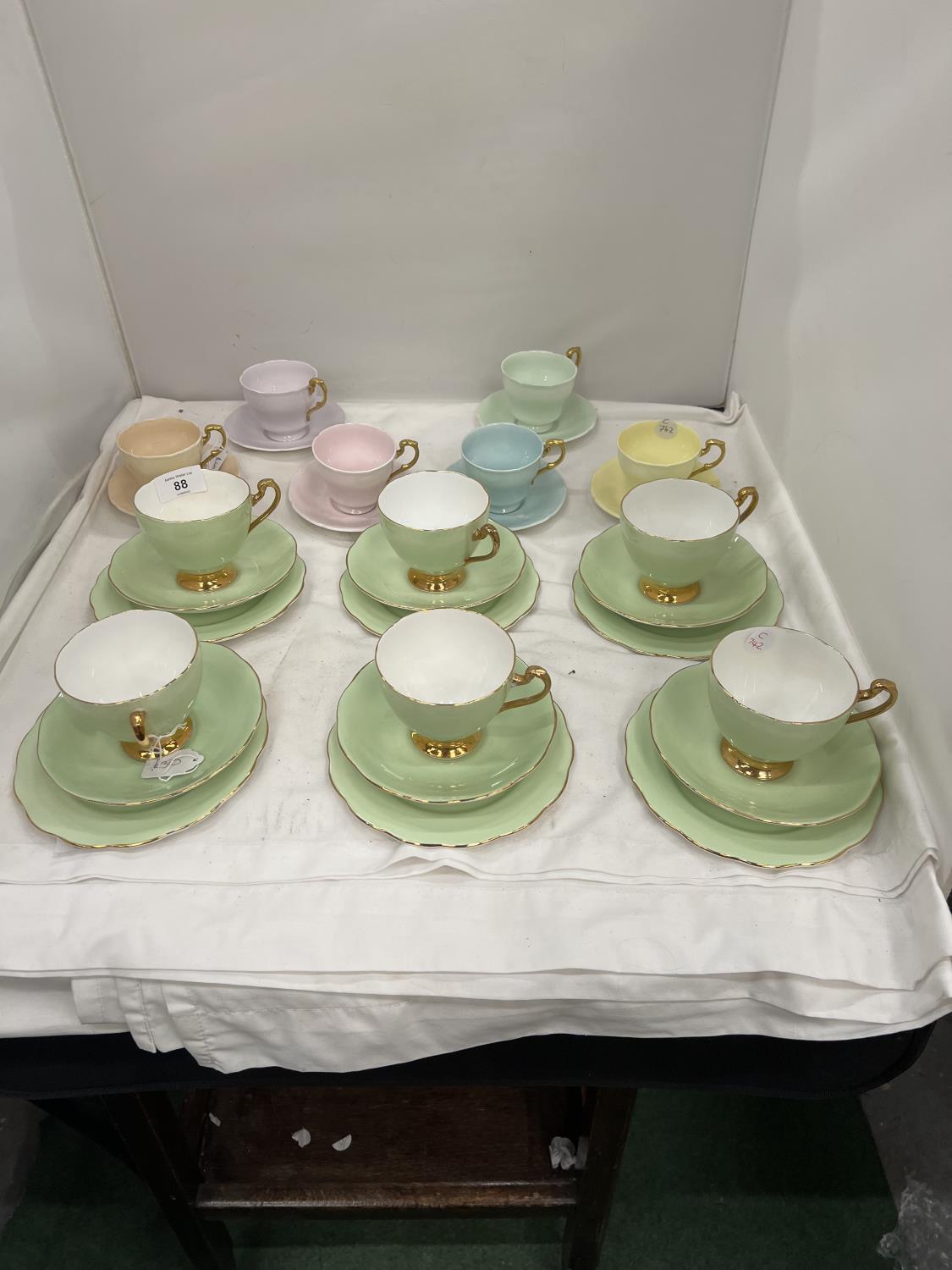 A SET OF SIX 'PARAGON' SMALL CUPS AND SAUCERS IN DIFFERENT COLOURS PLUS A SET OF SIX ROSLYN CHINA
