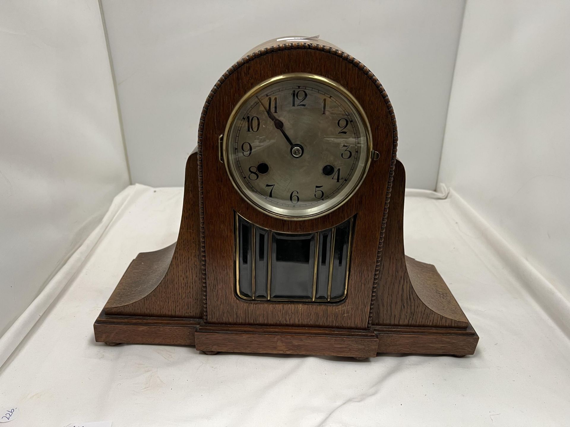 AN OAK CASED ART DECO STYLE MANTLE CLOCK WITH BEADED AND GLASS FRONT HEIGHT 31CM, WIDTH 40CM