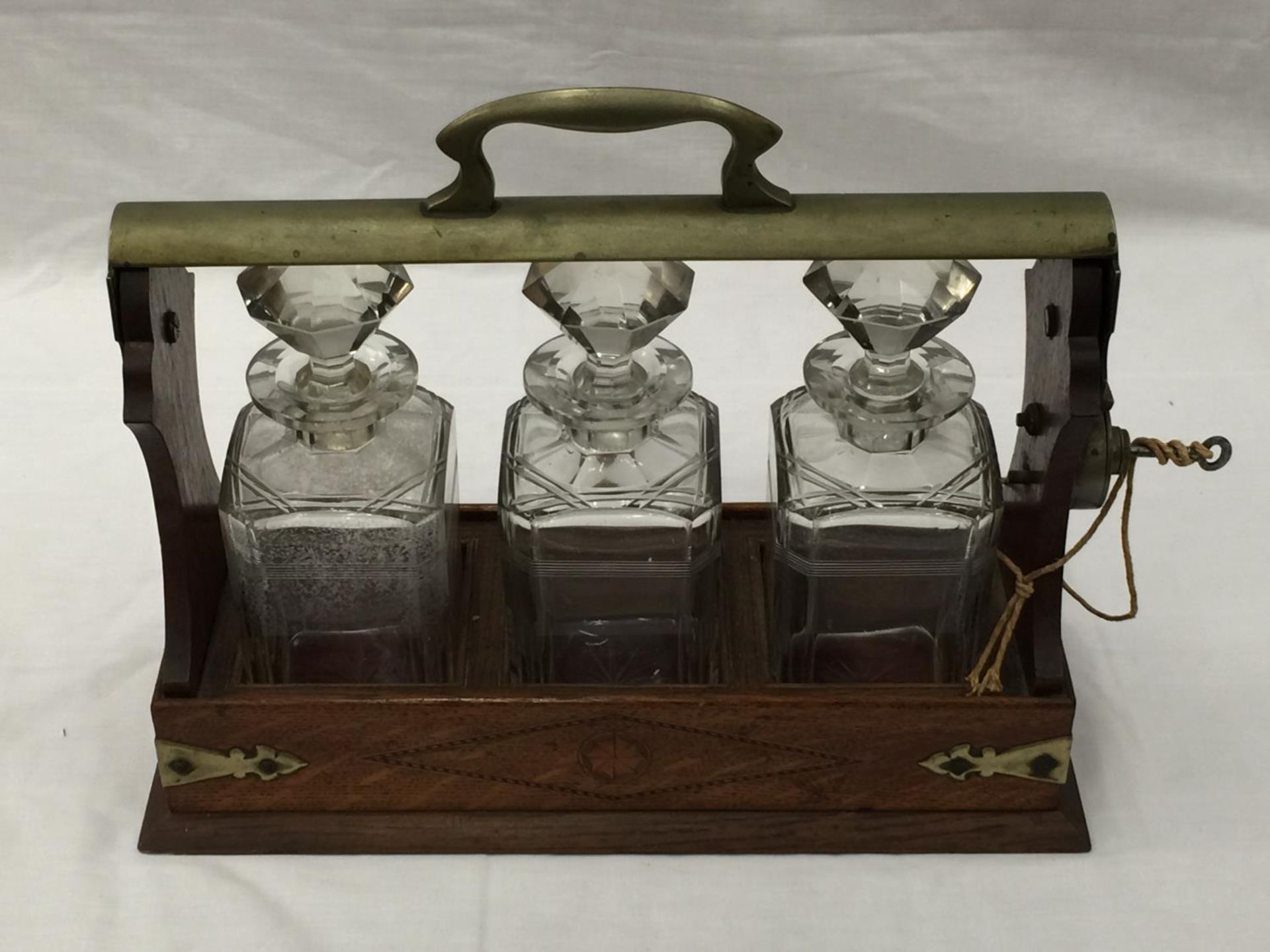 A VINTAGE MAHOGANY AND BRASS TANTALUS WITH THREE MATCHING DECANTERS AND KEY - Image 2 of 16