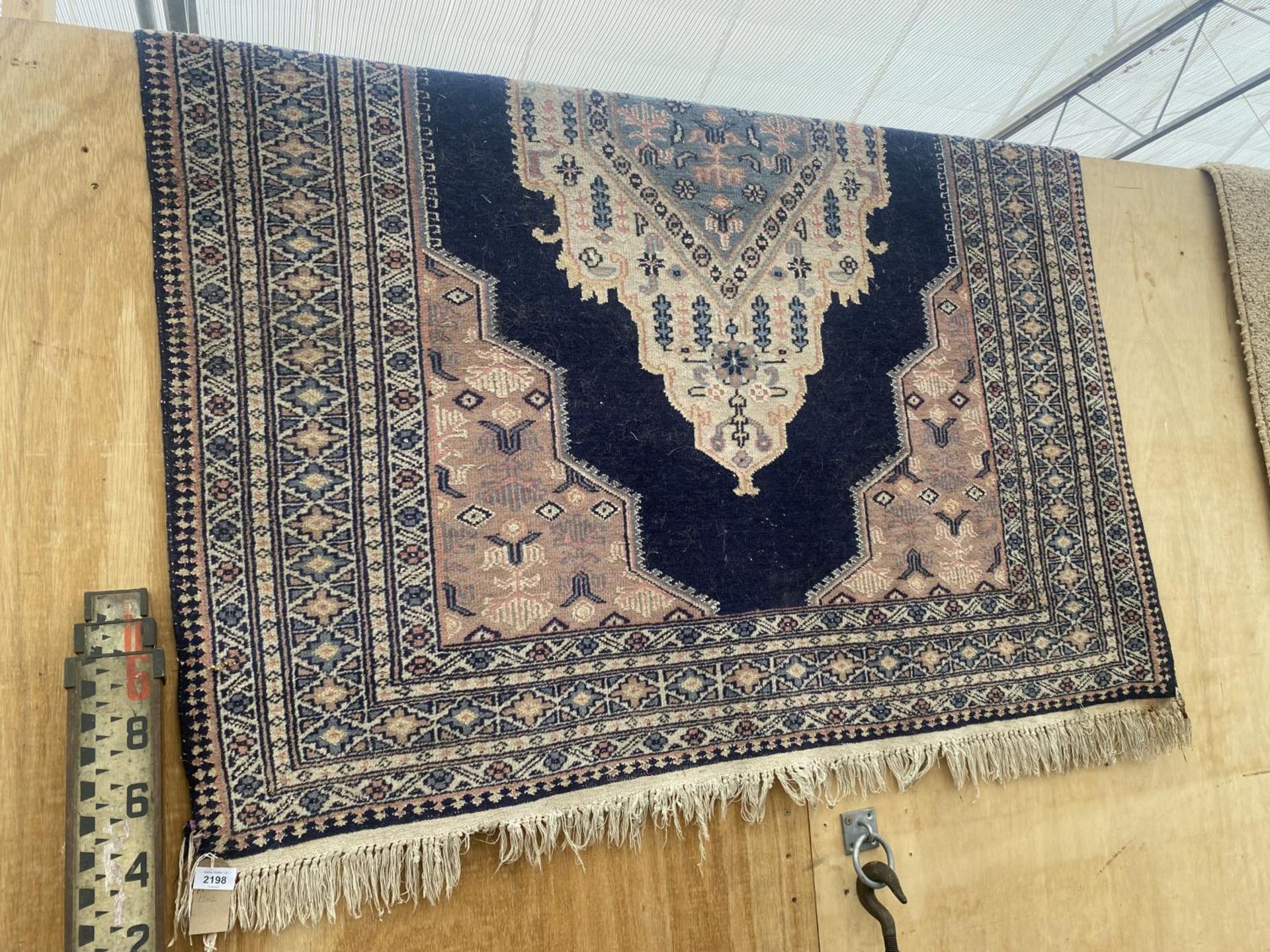 A BLUE PATTERNED FRINGED RUG