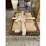 A WOODEN TRAY WITH LINEN TABLE CLOTH AND NAPKINS