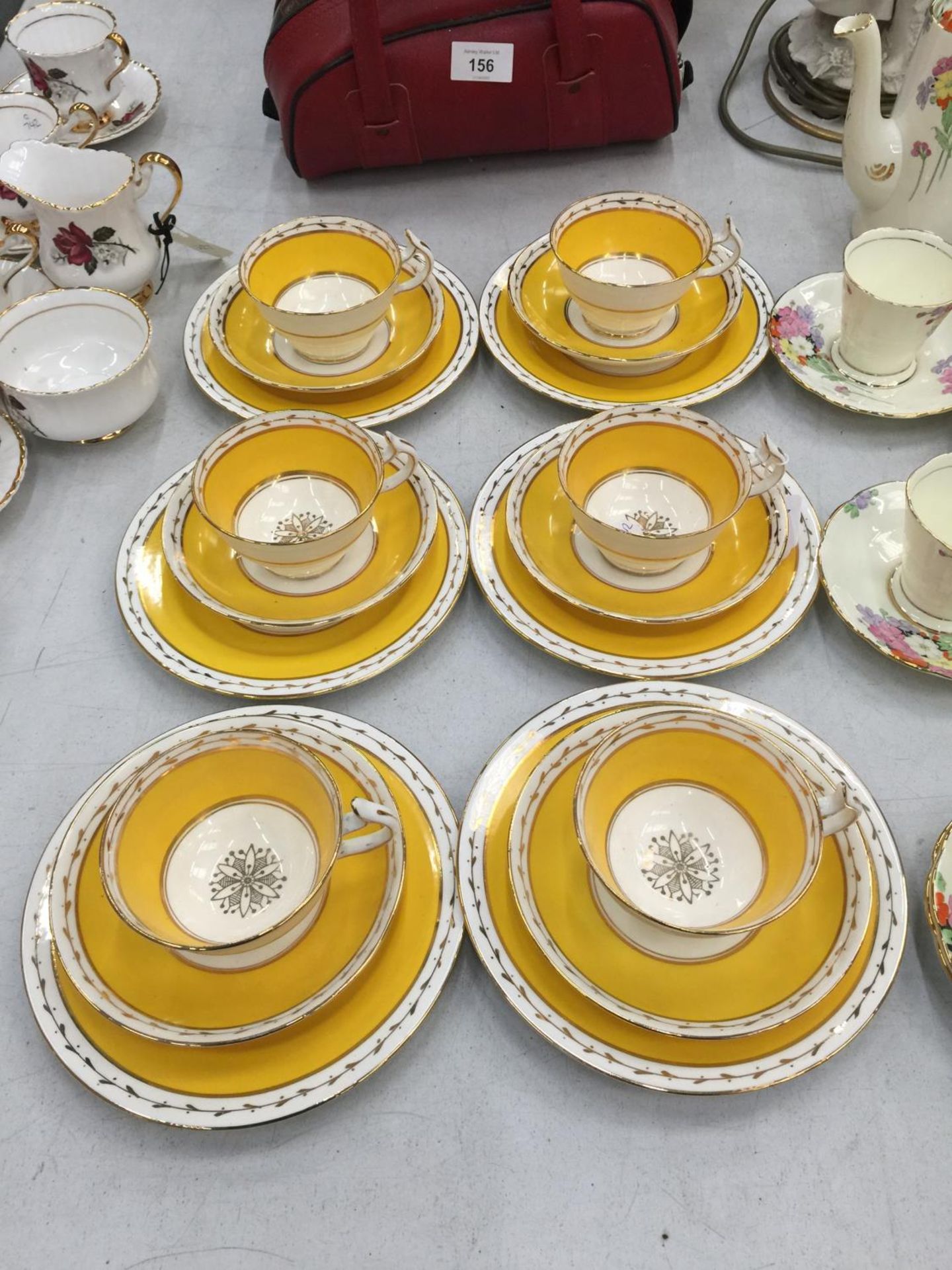 A QUANTITY OF WETLEY CHINA CUPS, SAUCERS AND PLATES IN A VIBRANT YELLOW AND GUILD COLOUR