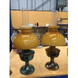 A PAIR OF VINTAGE BRASS OIL LAMPS WITH APRICOT COLOURED GLASS SHADES A/F REPAIRS TO ONE GLASS SHADE