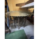 A LARGE SIX LEGGED FOLDING TABLE WITH BRASS TOP DEPICTING EGYPTIAN LIFE DIAMETER 73CM