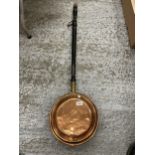 A COPPER BED WARMING PAN WITH A MAHOGANY HANDLE