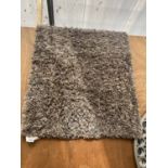 A SMALL MODERN BROWN RUG