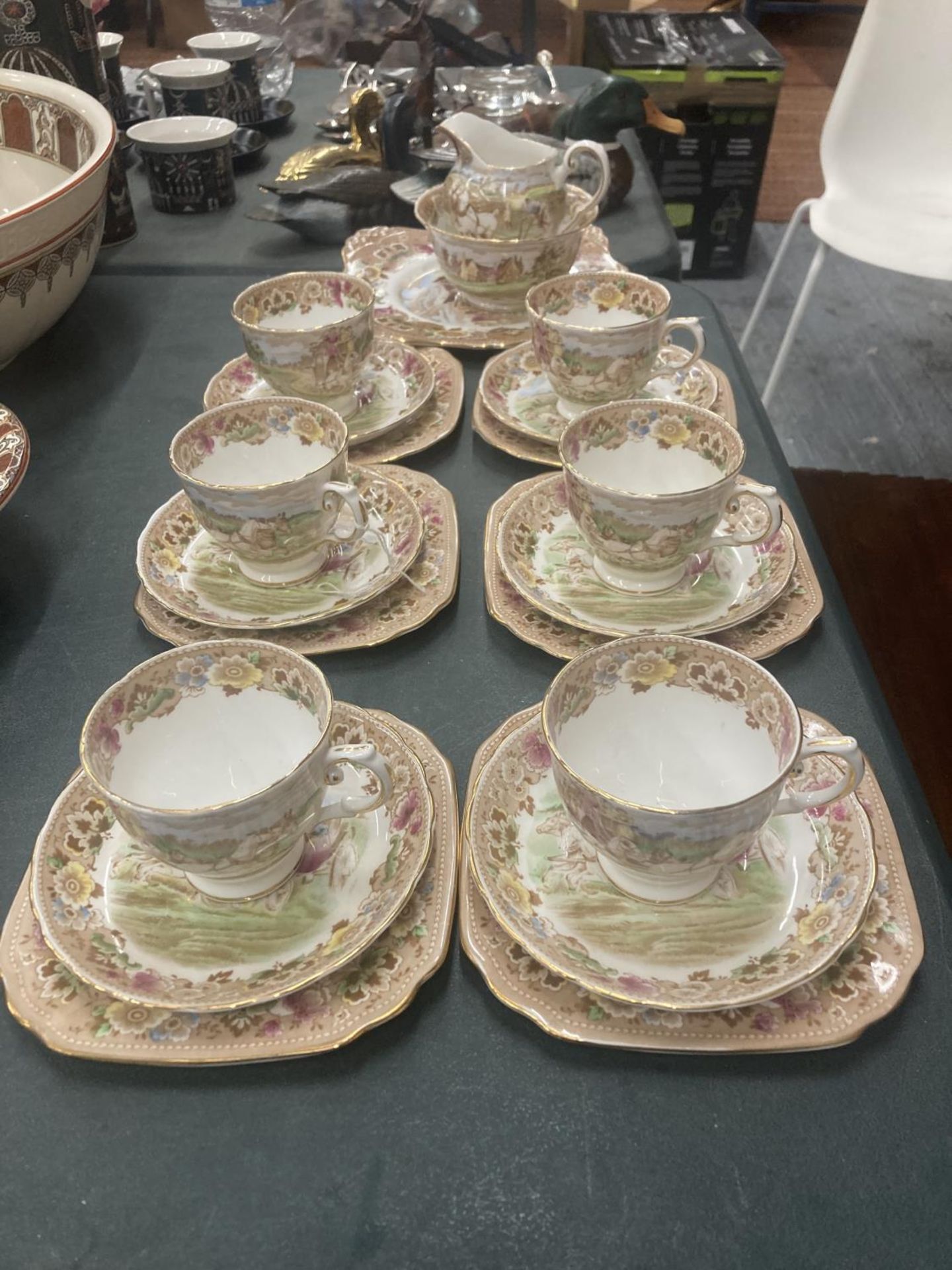 A TUSCAN TEASET WITH A COACHING SCENE DESIGN TO INCLUDE A CAKE PLATE, CREAM JUG, SUGAR BOWL, CUPS,