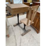 A VICTORIAN ELM CHILDS SCHOOL DESK WITH DOUBLE HINGED LID ON CAST IRON BASE WITH INTEGRAL CHAIR