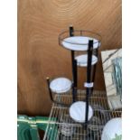 A SMALL METAL FOUR TIER PLANT STAND