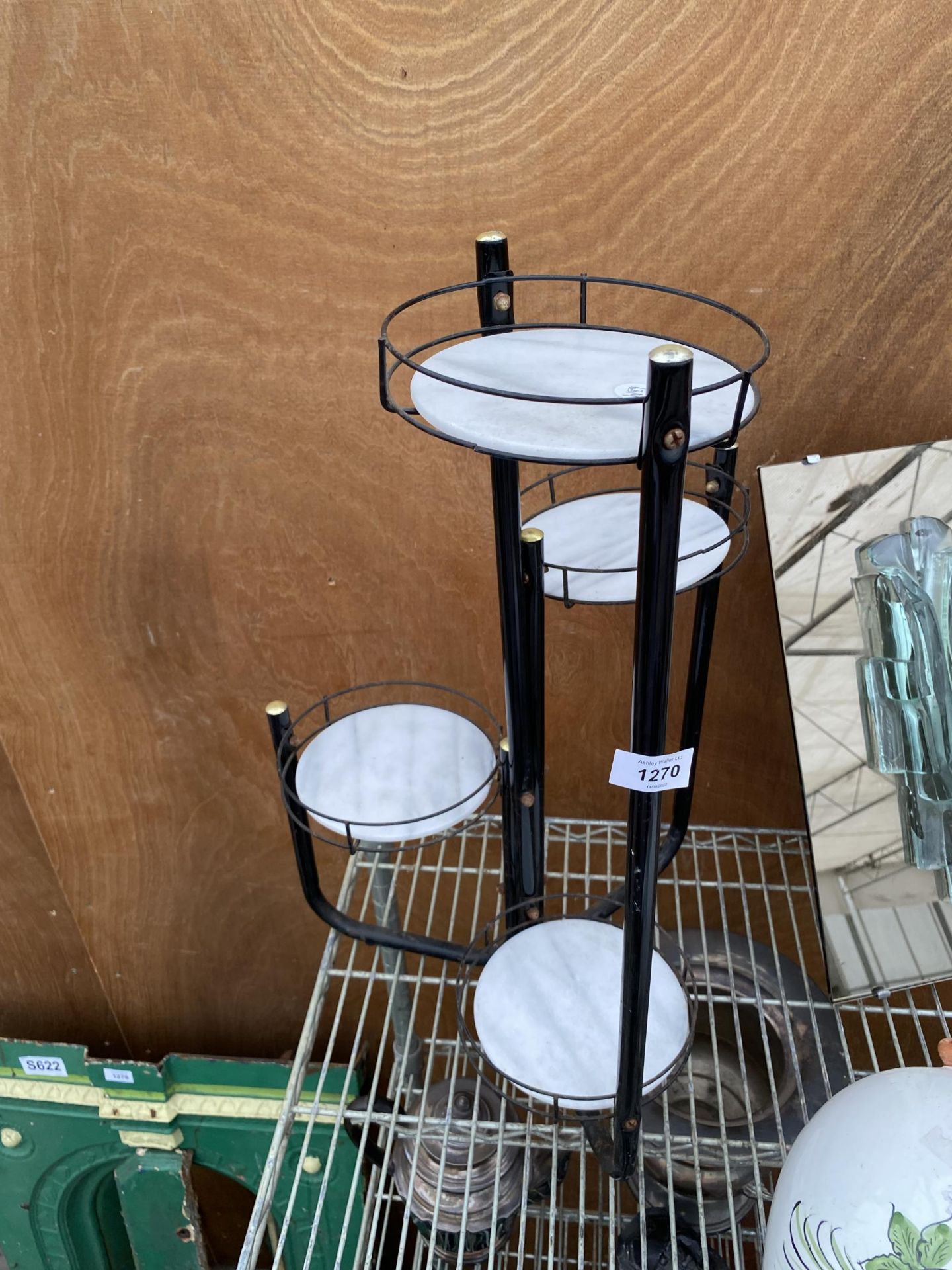 A SMALL METAL FOUR TIER PLANT STAND