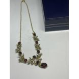 A 9 CARAT GOLD NECKLACE WITH GARNETS