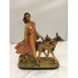 AN EARLY 20TH CENTURY ART DECO STYLE CHALKWARE FIGURE OF A LADY AND TWO GERMAN SHEPHERDS MARKED RD
