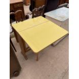 A VIVID YELLOW FORMICA TOPPED DROP-LEAF TABLE