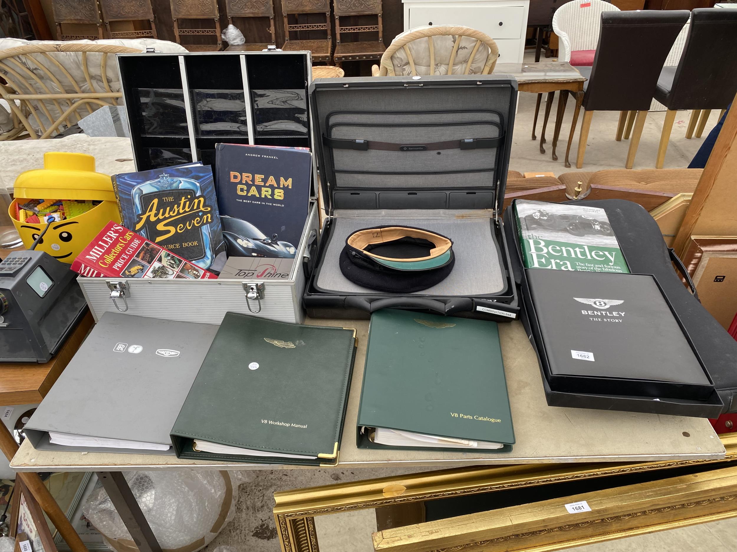 AN ASSORTMENT OF CAR ITEMS TO INCLUDE ASTON MARTIN MANUALS, BENTLEY BOOKS, A SAMSONITE BRIEFCASE AND