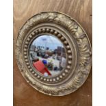 A DECORATIVE ROUND GILT FRAMED WALL MIRROR