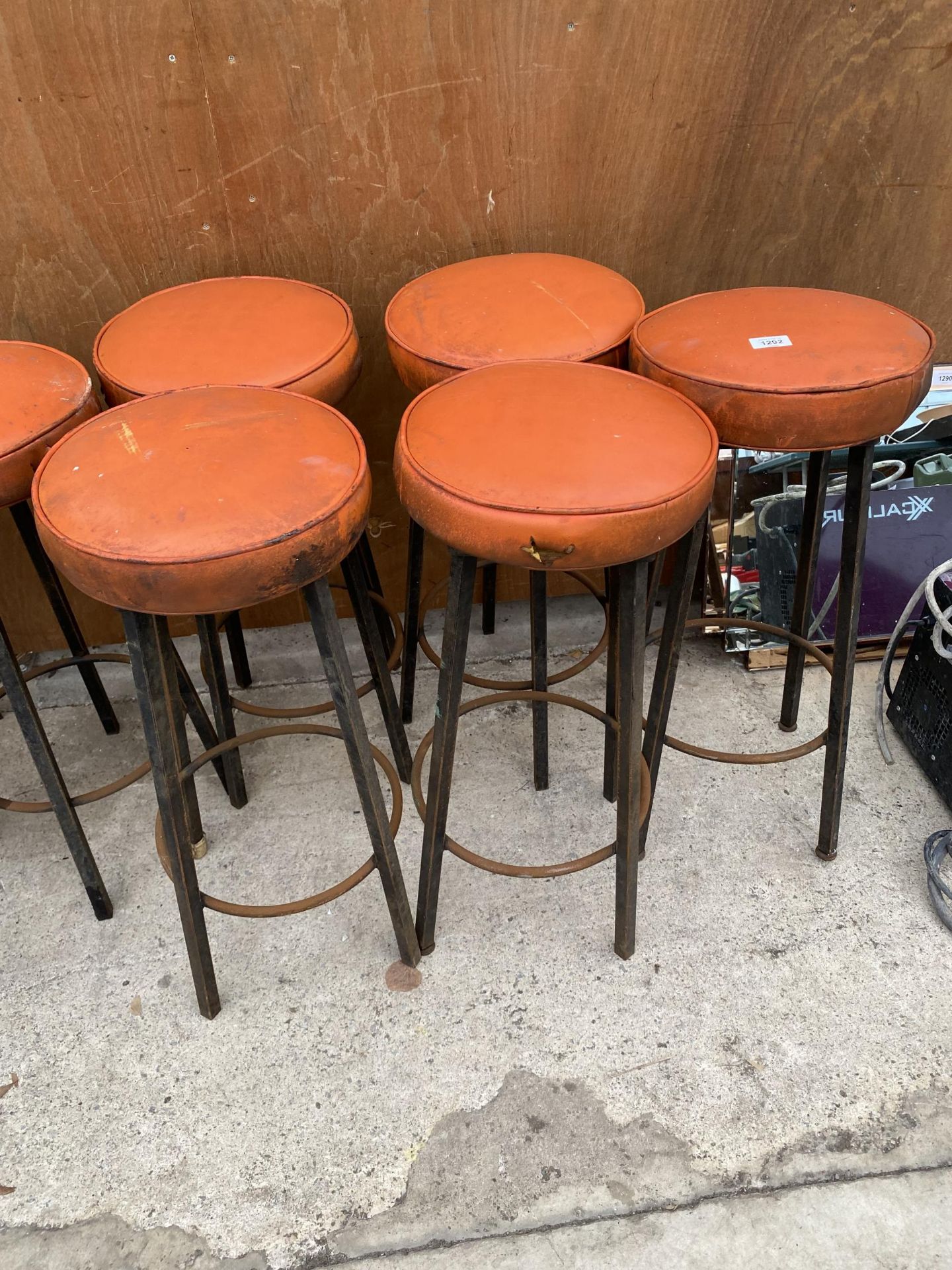 A SET OF SIX RETRO ORANGE BAR STOOLS WITH METAL LEGS