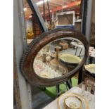 A LATE VICTORIAN WALNUT FRAMED OVAL BEVELLED MIRROR 84CM X 53CM
