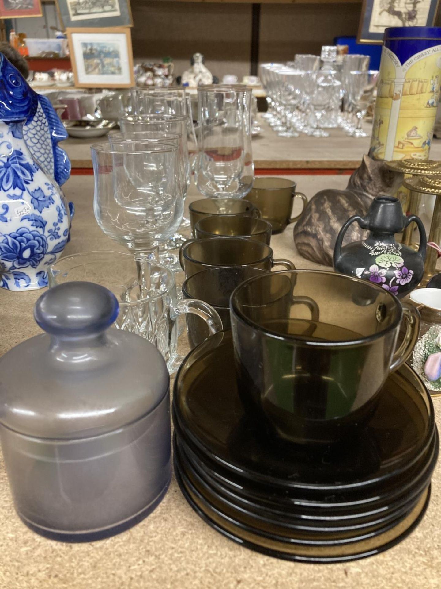 A QUANTITY OF WINE GLASSES, SMOKY GLASS CUPS AND SAUCERS, ETC