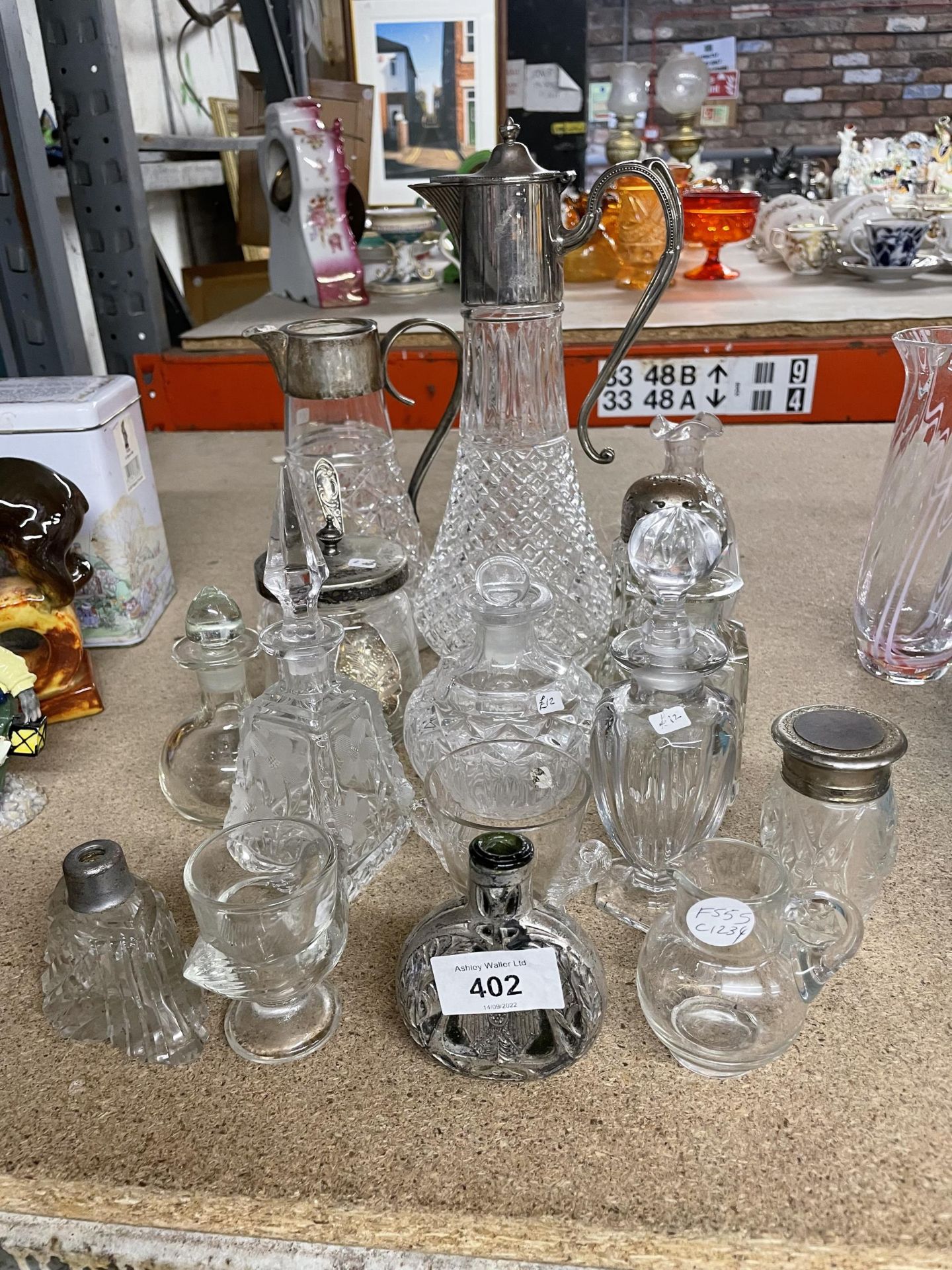 A COLLECTION OF GLASSWARE TO INCLUDE SILVER PLATED GLASS JUGS, OIL BOTTLES, LIDDED JARS, ETC