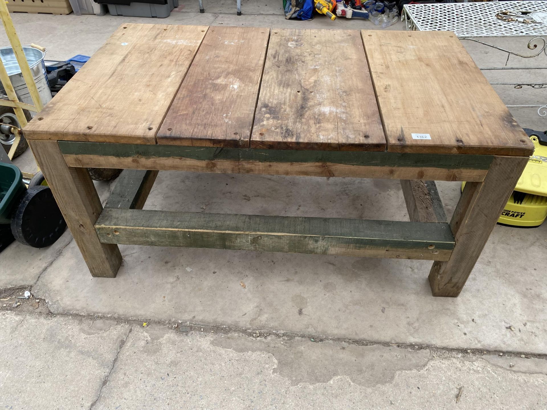 A WOODEN PLANK TOP OUTDOOR COFFEE TABLE