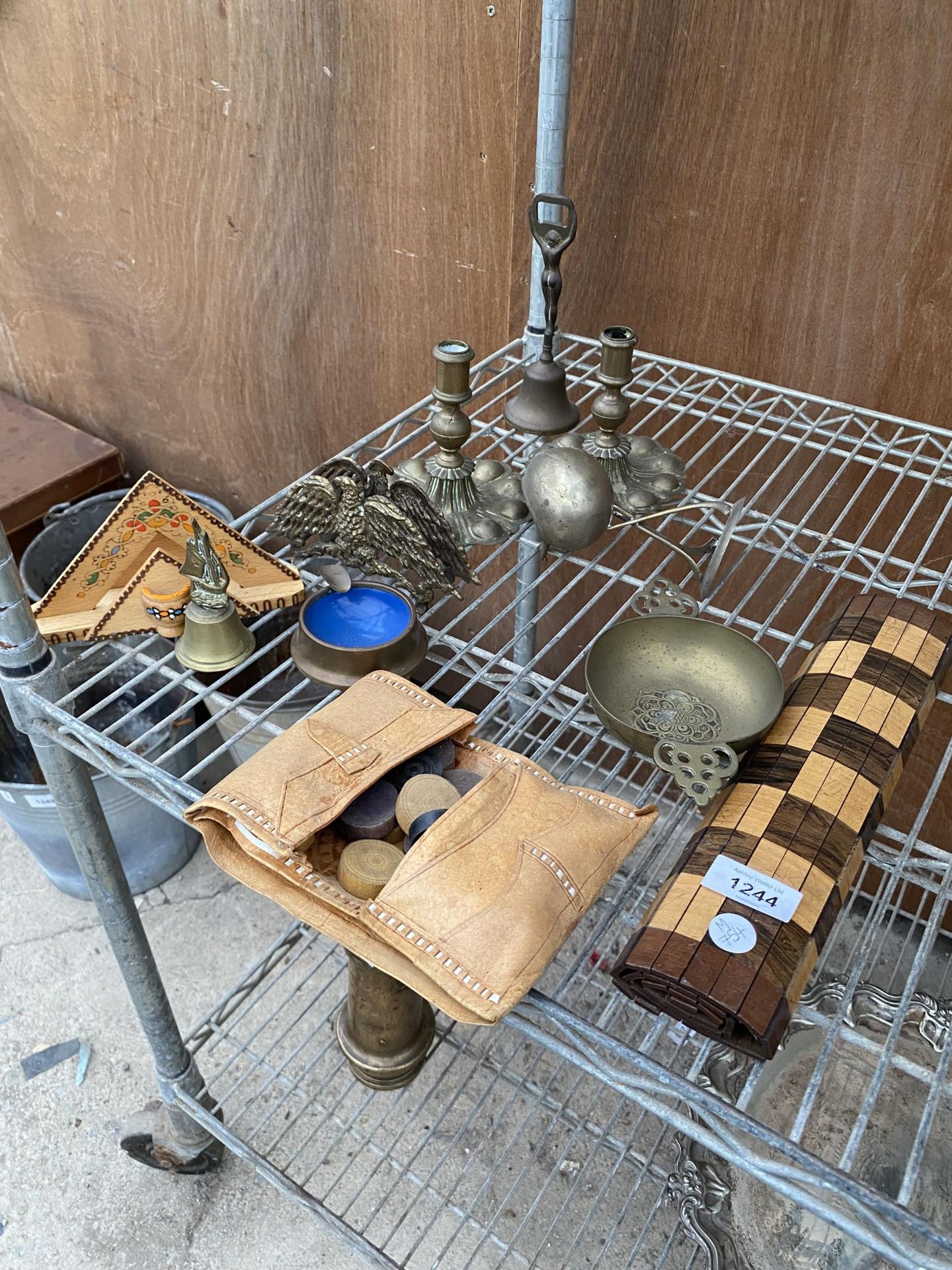 AN ASSORTMENT OF ITEMS TO INCLUDE CANDLESTICKS, A BRASS BELL AND AN ASHTRAY ETC