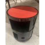 A VINTAGE STYLE RETRO BLACK CYLINDRICAL STOOL WITH TWO SLIDE DRAWER CUPBOARDS AND A RED SEAT