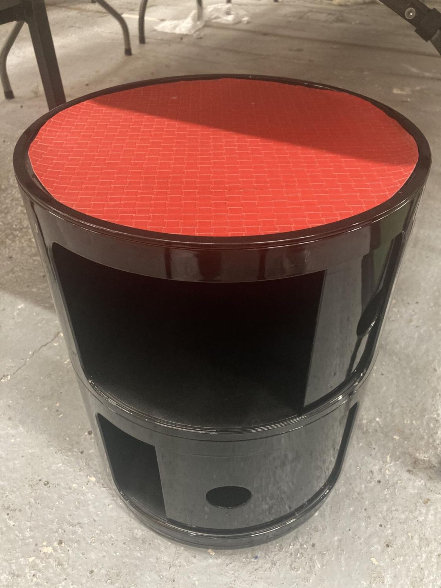 A VINTAGE STYLE RETRO BLACK CYLINDRICAL STOOL WITH TWO SLIDE DRAWER CUPBOARDS AND A RED SEAT