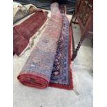 A LARGE RED PATTERNED FRINGED RUG (162" X 107")