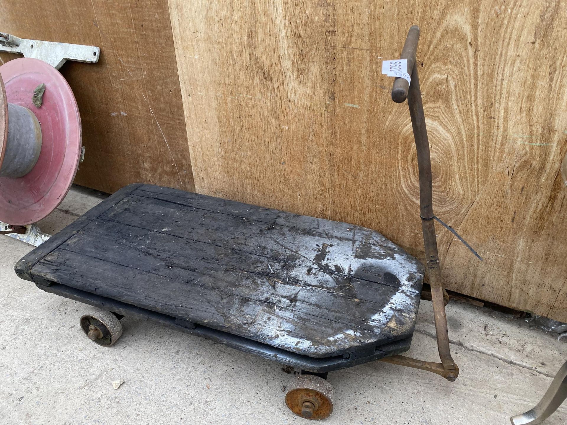 A VINTAGE CAST IRON AND WOODEN PLANK FOUR WHEELED TROLLEY